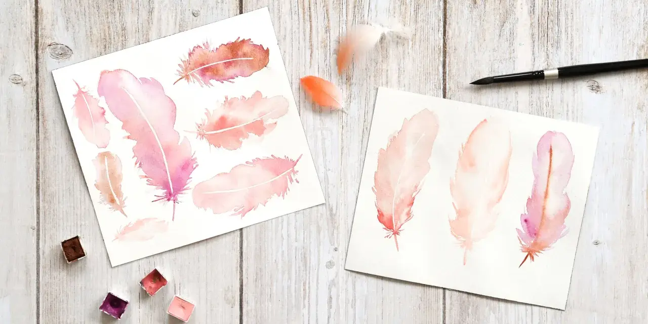 Aquarelles de plumes roses et orangées sur papier, avec des godets de peinture acrylique et un pinceau.
