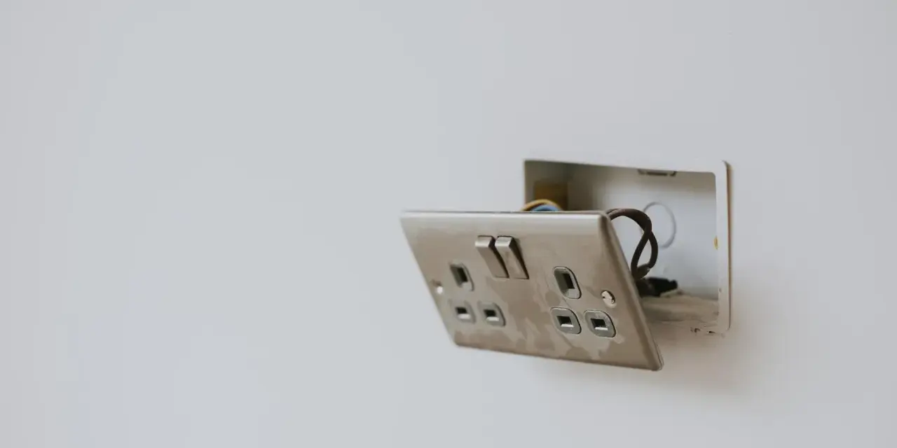 Enchufe con interruptor abierto, mostrando cables. Guía visual para como conectar un enchufe interruptor y bombilla.