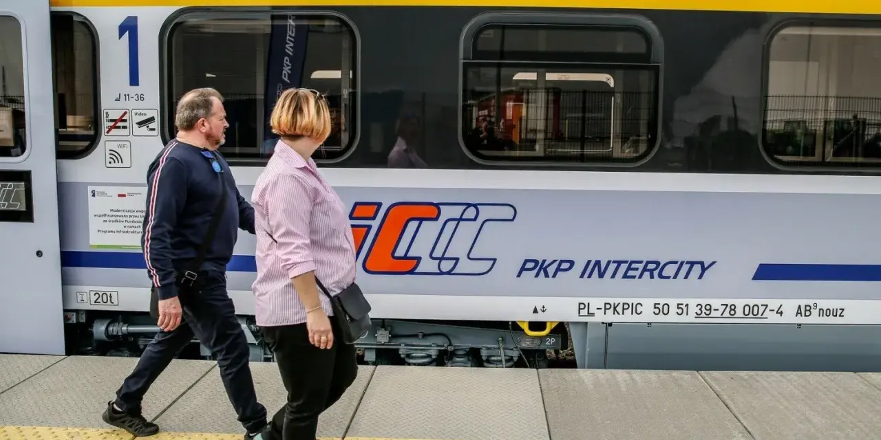 Para podróżuje obok pociągu PKP Intercity, który może zabrać ich z Rzeszowa do Krakowa.