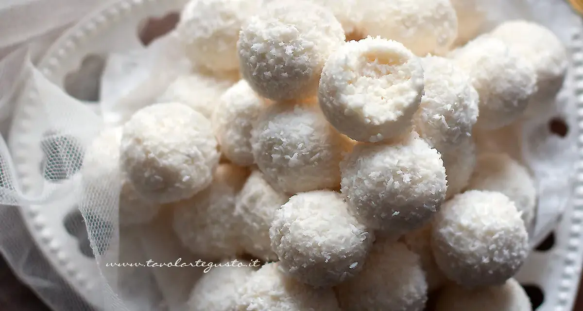 Dolci palline di cocco, morbide e profumate, adagiate su un piatto decorato con un velo di tulle.
