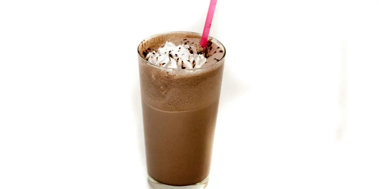Un delizioso frappè al cioccolato con panna montata e una cannuccia rosa.