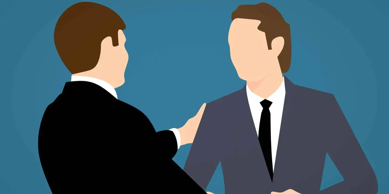 Deux hommes en costume se serrent la main, symbolisant un accord mutuel pour comment négocier une rupture conventionnelle.
