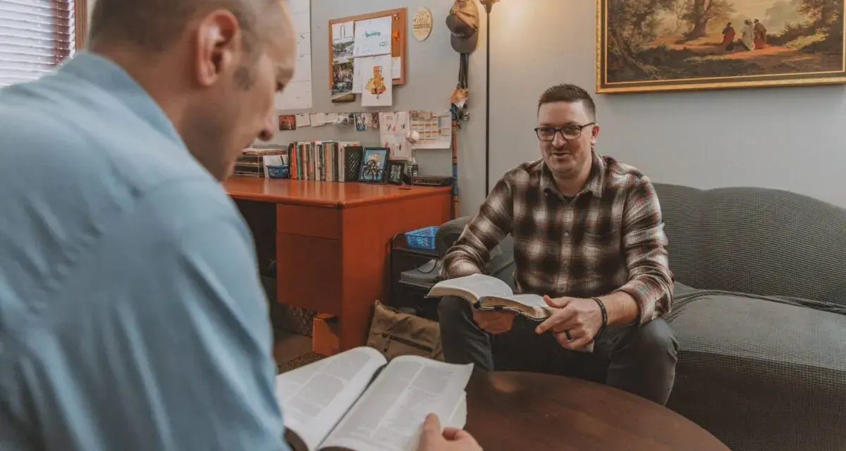 Two men discuss the Bible, exploring why God sent Jesus to save humanity.