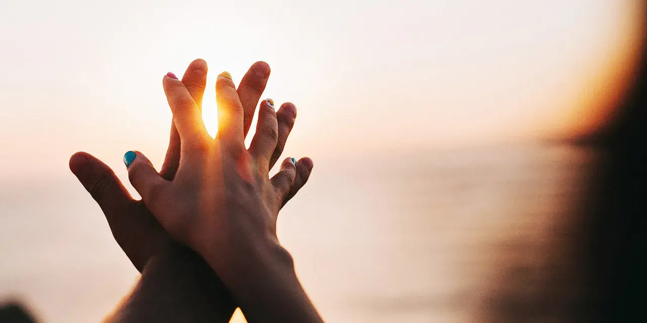 Two hands clasped at sunset, a symbol of purity and what is chastity: a deep, respectful connection.