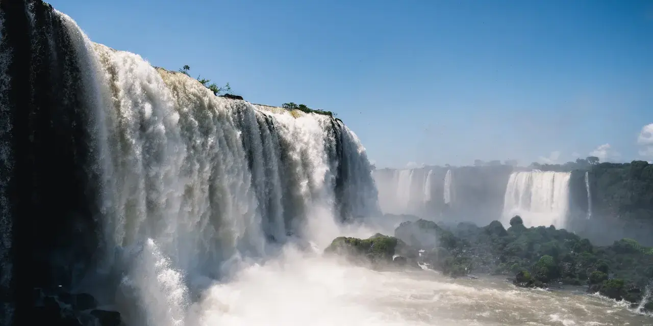 Potężne wodospady Iguazú w Argentynie, kaskady wody spadające z klifów, otoczone zielenią i spowite mgiełką.