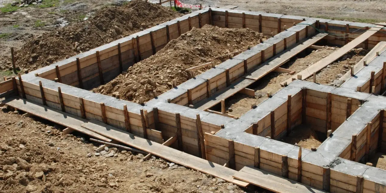 Zbrojenie ławy fundamentowej 40x60 w drewnianym szalunku, gotowe do zalania betonem.