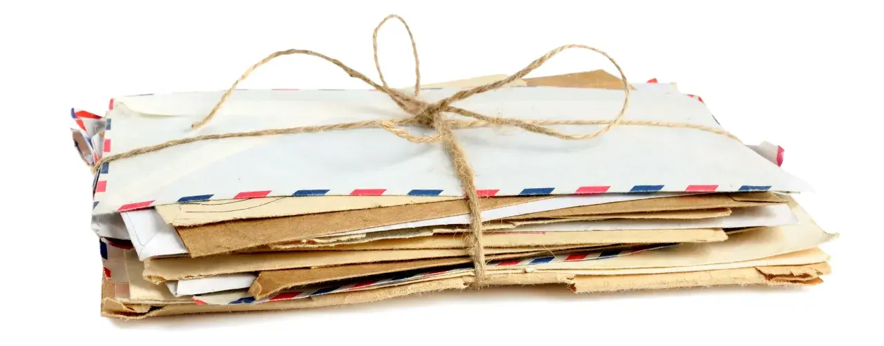 Stos listów w kopertach rozmiar C3, związany sznurkiem. Widać różne rodzaje papieru i ozdobne paski.