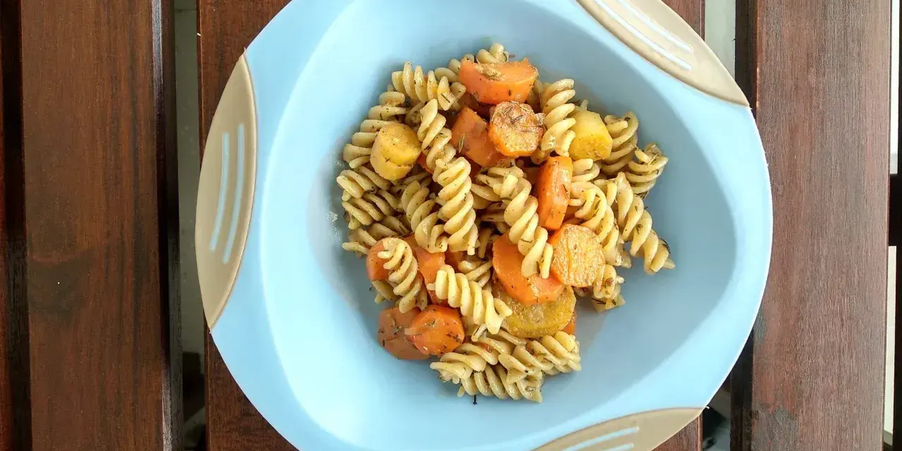 Kolacja dla niemowlaka 9 miesięcy: makaron fusilli z marchewką i ziemniakami, doprawione ziołami.