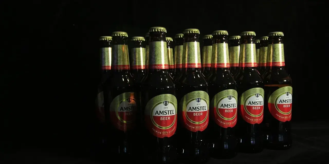 Rząd butelek piwa Amstel. Lepiej 2 drinki czy 2 piwa? Wybór należy do Ciebie, ale te piwa wyglądają kusząco.
