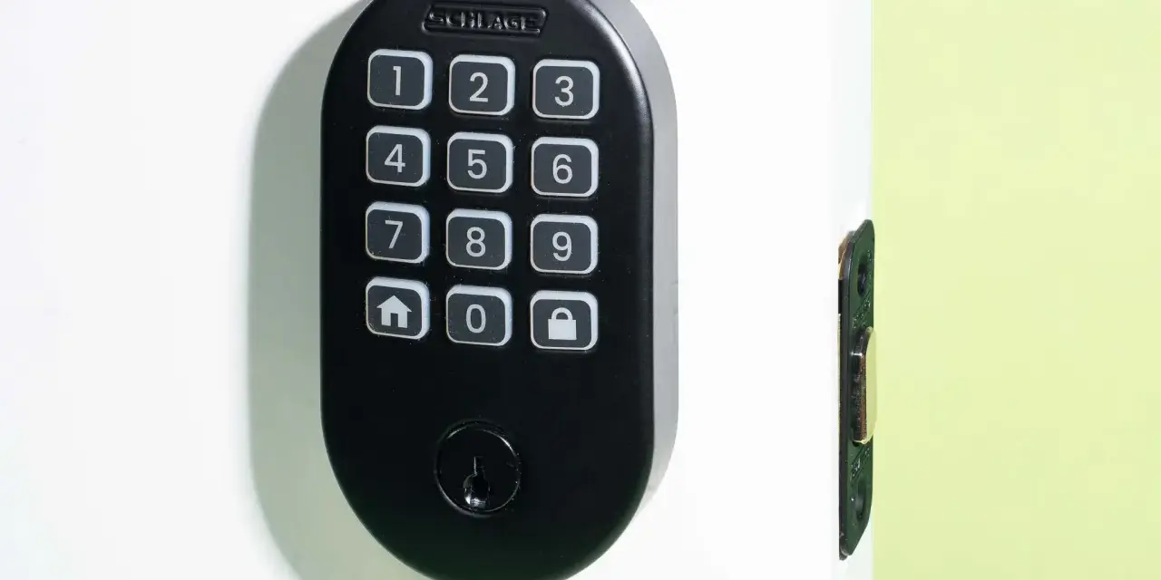 Black Schlage keypad lock on a white door, showing numbers and icons. Learn how to change door lock code for enhanced security.