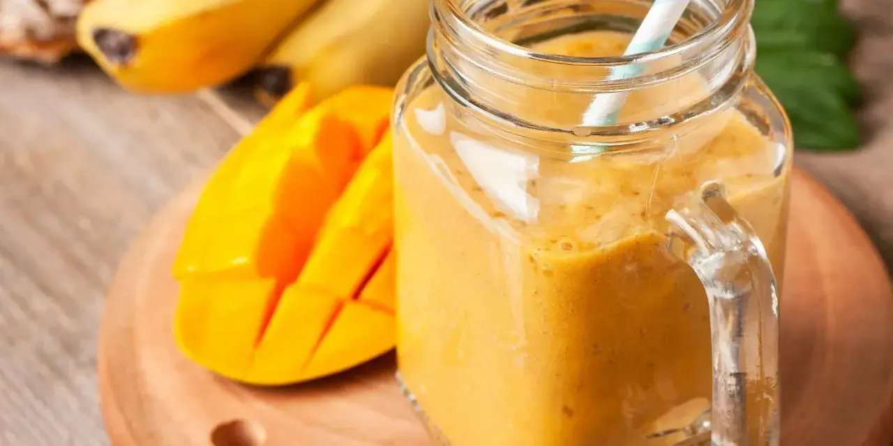 Słoneczny koktajl zamiast śniadania: gęsty, pomarańczowy napój z mango i bananów w słoiku, gotowy do wypicia.