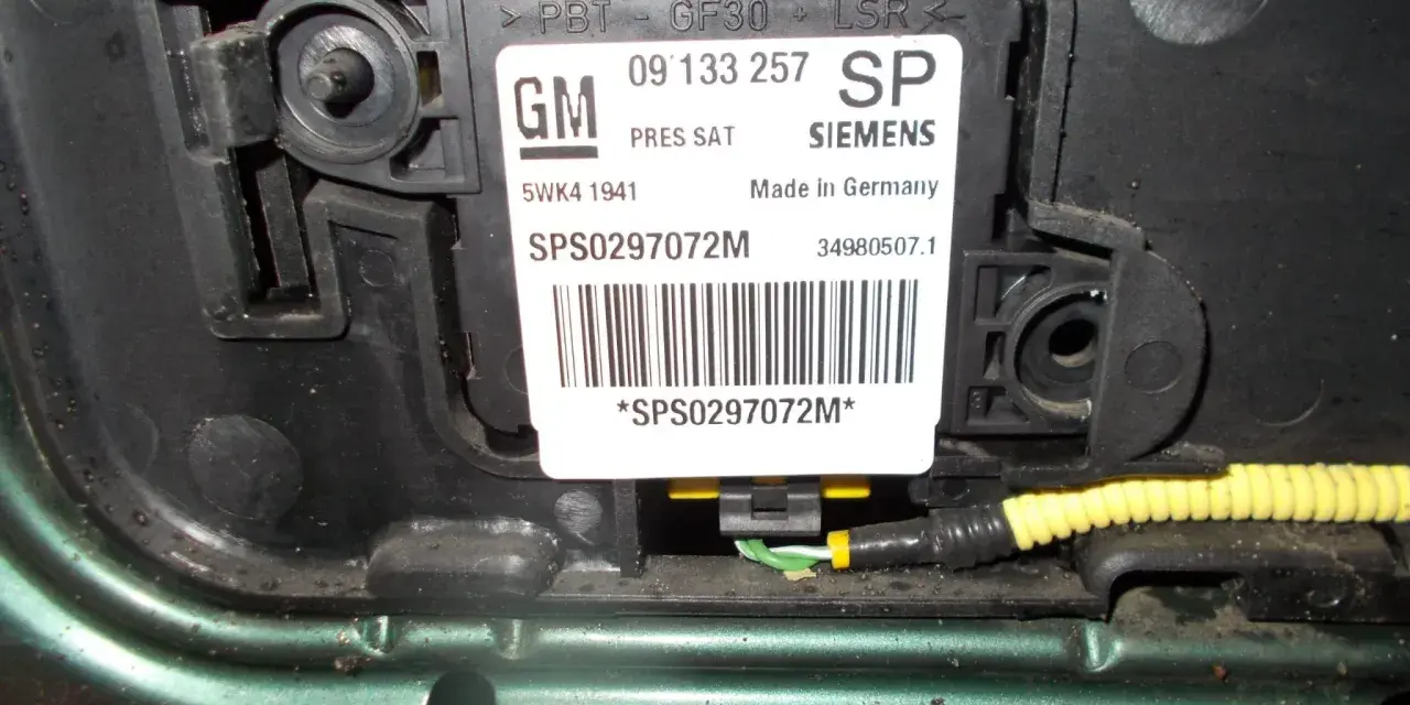 Widoczny czujnik uderzeniowy GM Siemens, zamontowany w samochodzie.