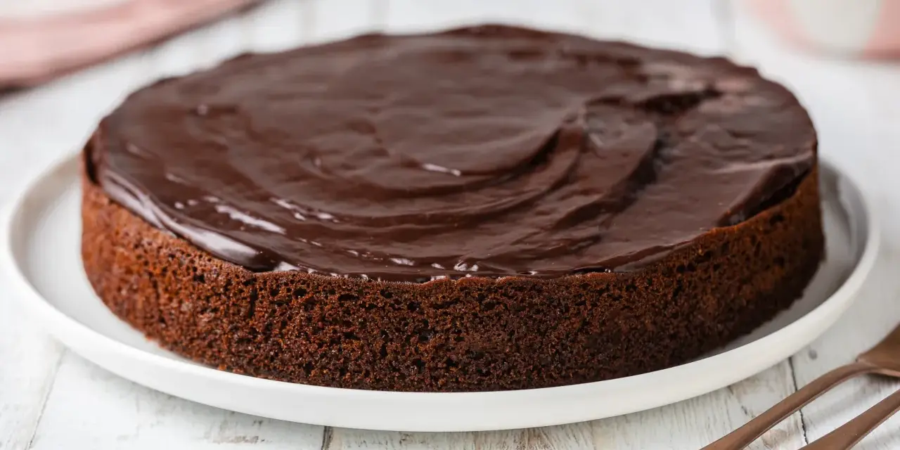 Torta al cioccolato soffice, ricoperta da una glassa lucida. Perfetta per chi ama il cioccolato, questa torta con cioccolato avanzato è un vero piacere.