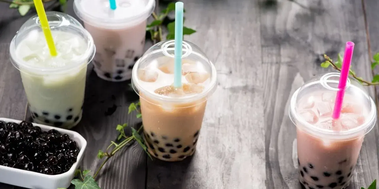 Różne rodzaje herbaty do bubble tea: zielona, mleczna, brązowa i różowa, z tapioką.