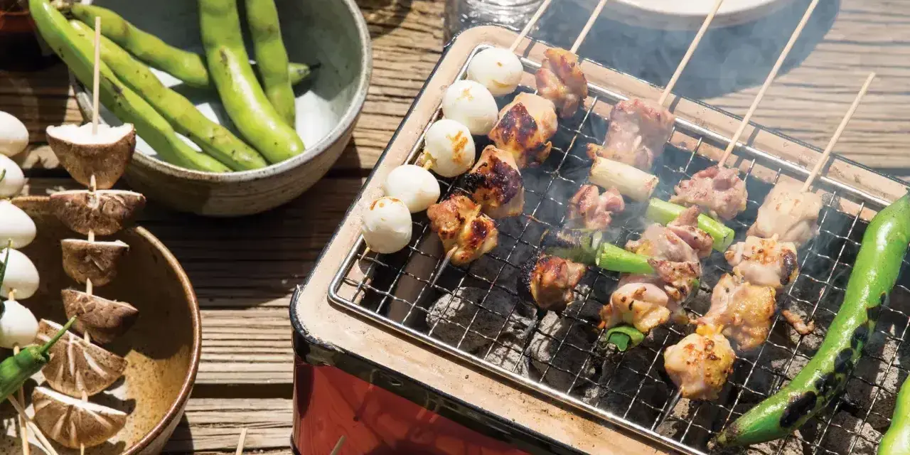 Grillowane **yakitori** z kurczakiem i warzywami, obok miska fasolki i grzybów na patyczkach.