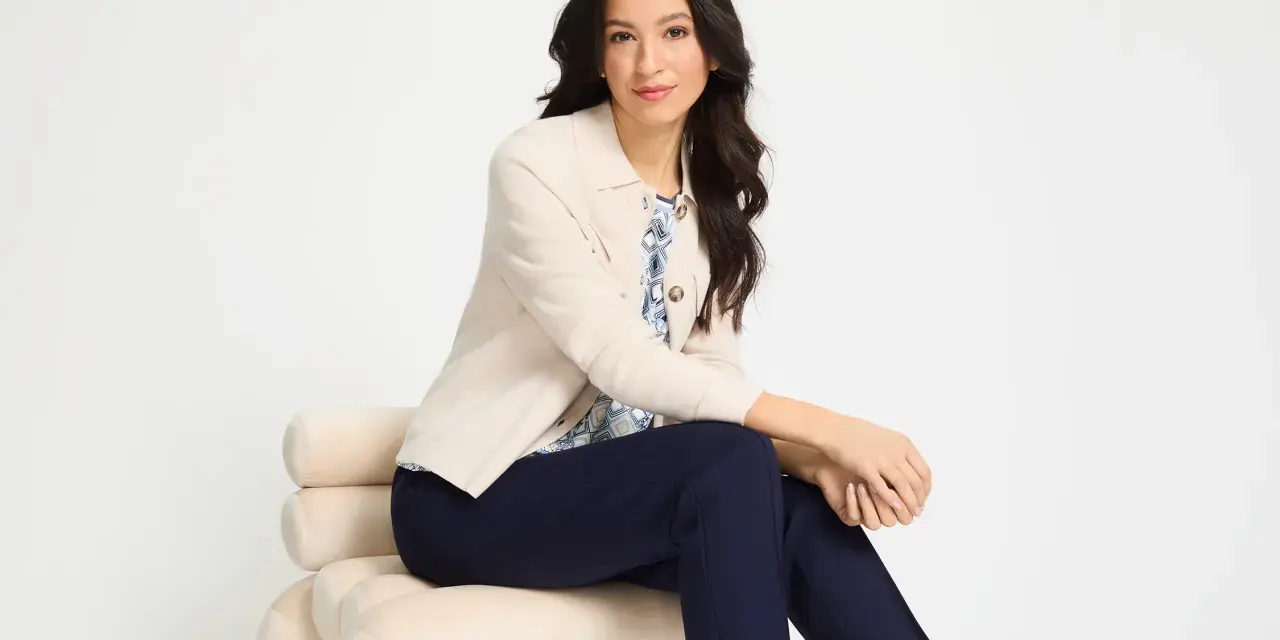 Elegancka kobieta w beżowej marynarce i granatowych spodniach prezentuje stylowe beżowa marynarka stylizacje.