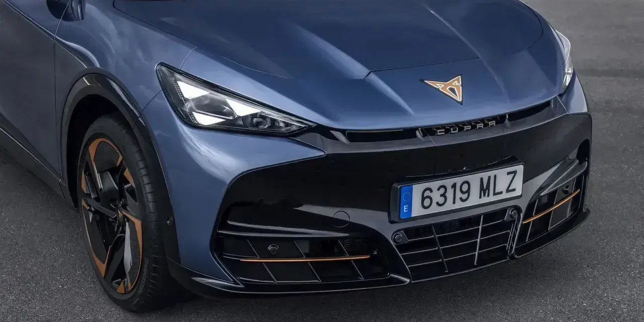 Niebieski Cupra Tavascan z miedzianymi akcentami i sportowym grillem.