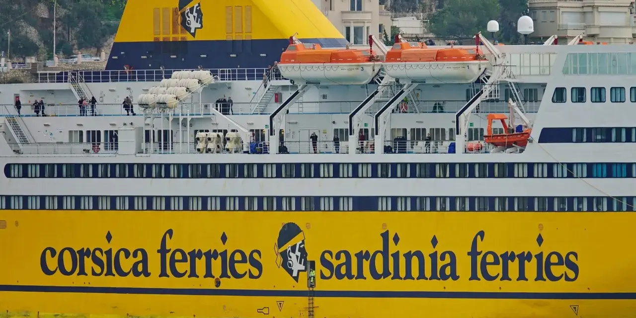 Żółty prom "Corsica Ferries Sardinia Ferries" z ludźmi na pokładzie, gotowy do podróży motocyklem na Sardynię.