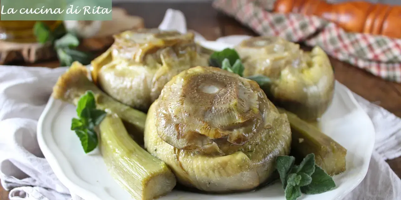 Carciofi alla romana cotti a puntino, teneri e saporiti, guarniti con menta fresca su un piatto bianco.
