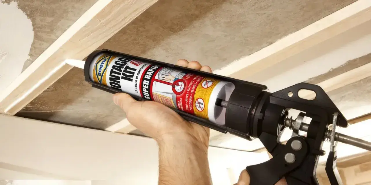 Uso di una pistola per colla per fissare il cartongesso a una struttura in legno.