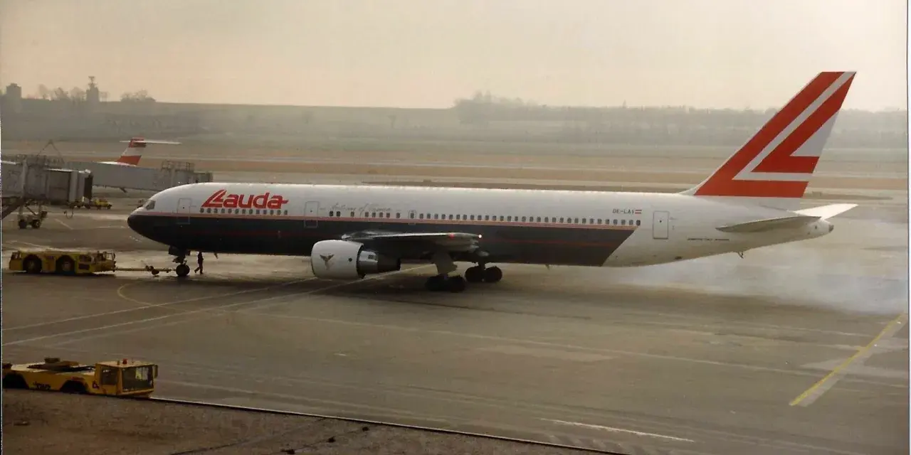 Samolot Lauda Air z charakterystycznym ogonem, kołujący po płycie lotniska.
