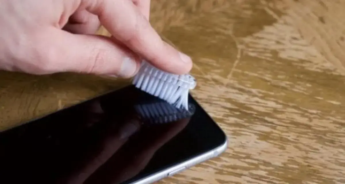 Delikatnie szczotkuj głośnik iPhone'a, aby usunąć kurz i brud. Prosty sposób, jak wyczyścić głośnik iPhone.