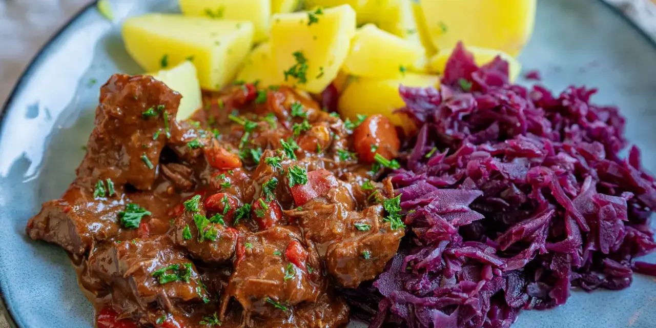 Herzhaftes Gulasch mit Kartoffeln und Rotkohl, ein klassisches Gulasch Rezept, das Leib und Seele wärmt.