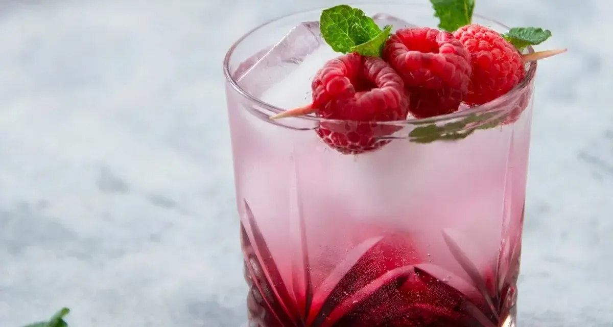 Orzeźwiający drink Wściekły Pies z malinami i miętą, idealny na letnie popołudnie.