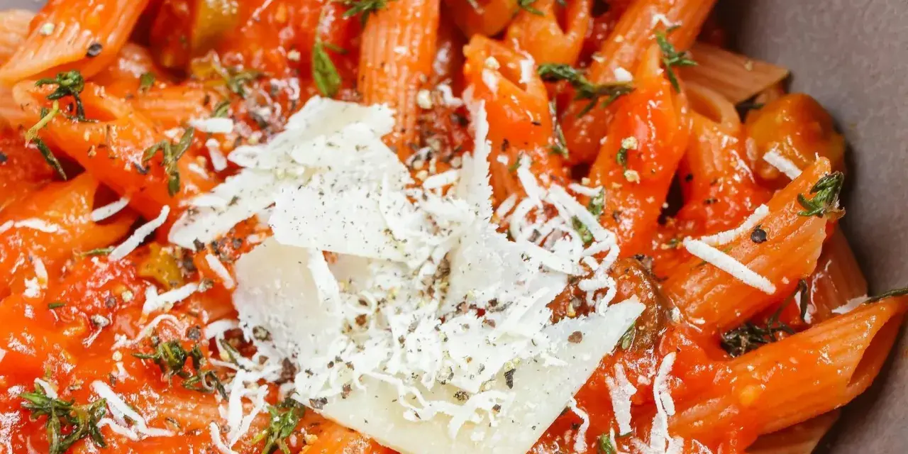 Szybki obiad z makaronem penne w sosie pomidorowym, z oliwkami i parmezanem. Idealny na szybki posiłek.