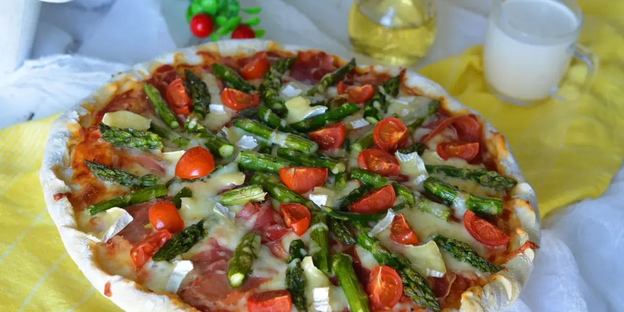 Pyszna pizza ze szparagami, pomidorkami i serem. Idealna na wiosenny obiad.