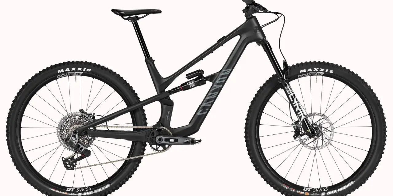 A black Canyon Spectral mountain bike, showcasing a mullet setup with a larger 29er front wheel and a smaller rear wheel, ready for any trail.