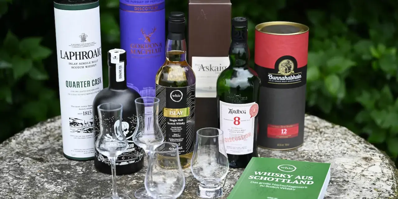 Laphroaig Aussprache: Eine Auswahl schottischer Single Malts, darunter Laphroaig Quarter Cask, Ardbeg 8, Bunnahabhain 12 und mehr, bereit für eine Verkostung.