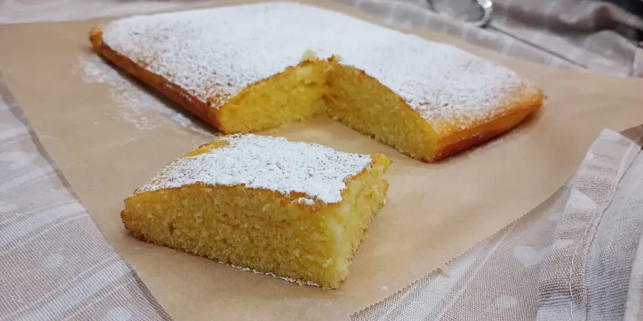 Ein saftiger Kuchen, bestäubt mit Puderzucker, ideal für glutenfreie rezepte mit reismehl.