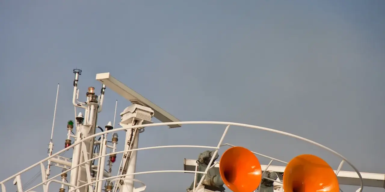 Zwei orangefarbene Schiffshörner sind bereit, ihr Signal zu geben. Das Schiff hupt 3 mal lang, um seine Anwesenheit zu signalisieren.