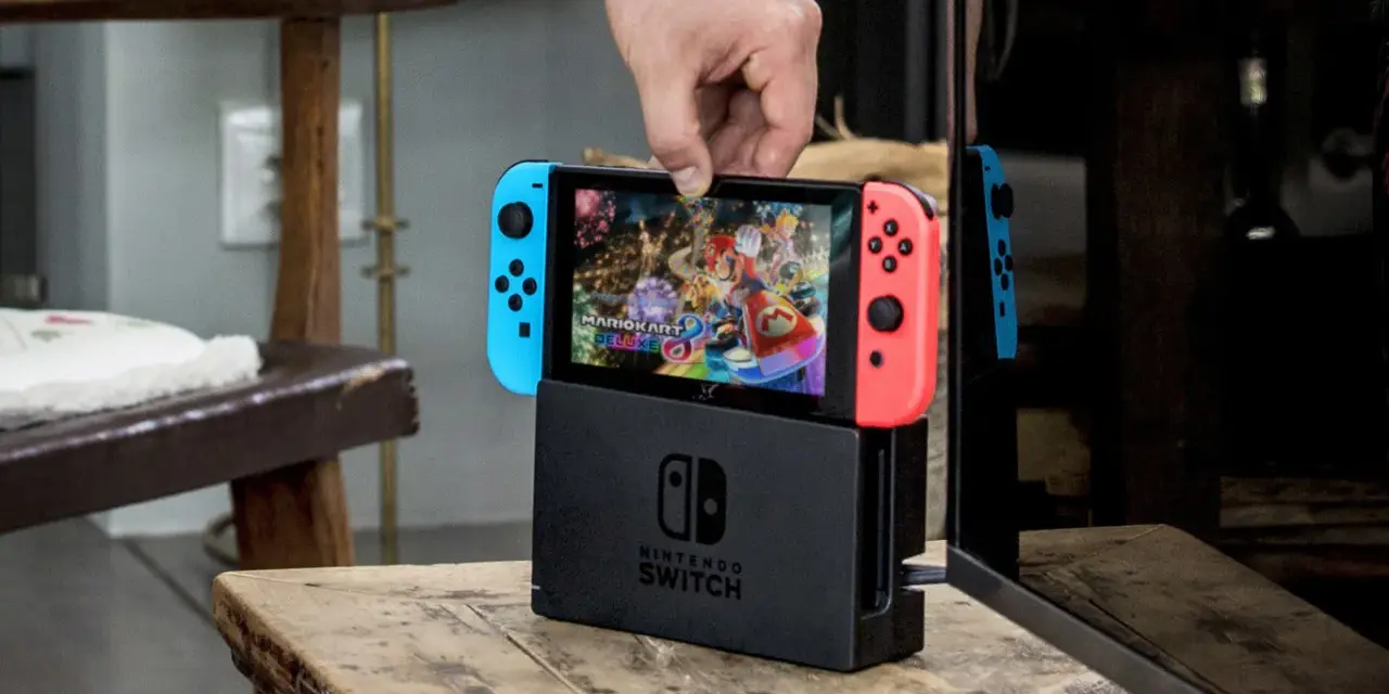 Mano insertando la Nintendo Switch en su base, lista para jugar Mario Kart 8 Deluxe, uno de los mejores juegos estrategia switch.