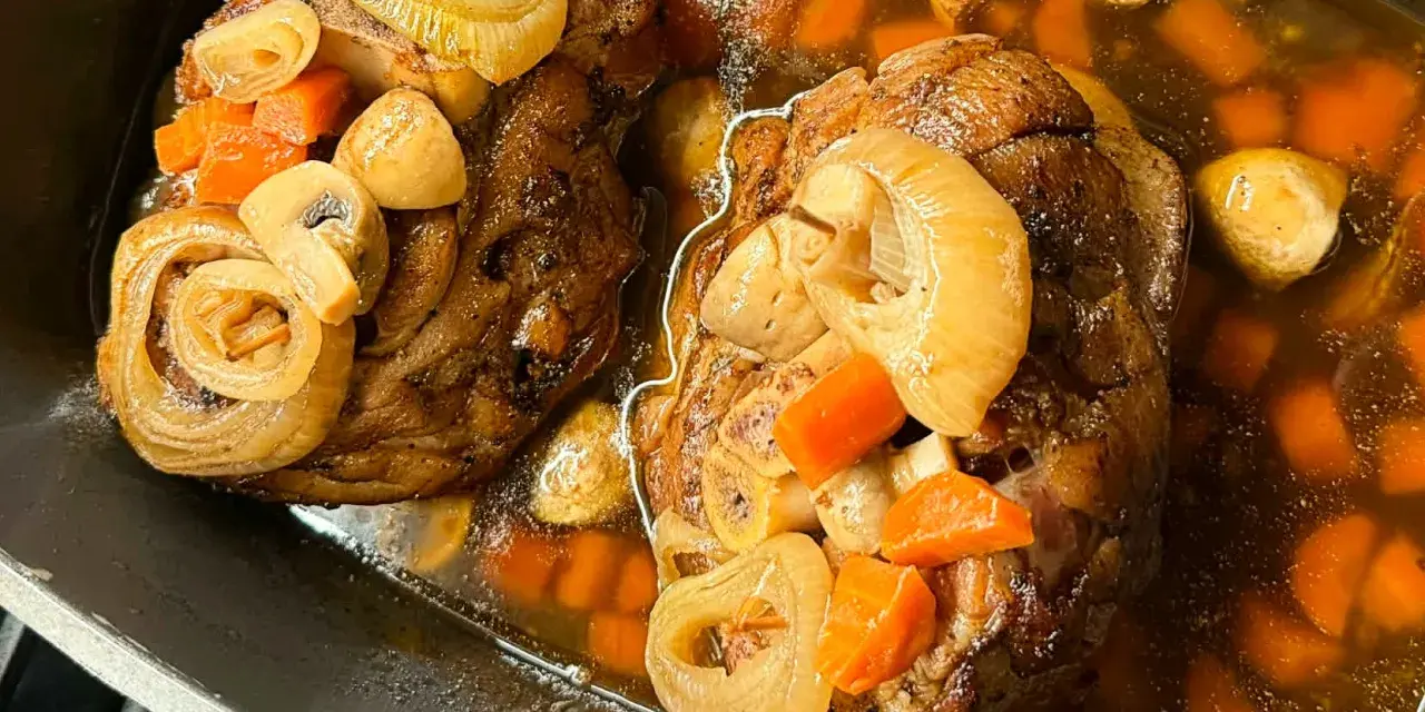 Dwie soczyste golonki, gotowane i pieczone, w aromatycznym sosie z marchewką, cebulą i grzybami. Najlepsza golonka gotowana i pieczona.