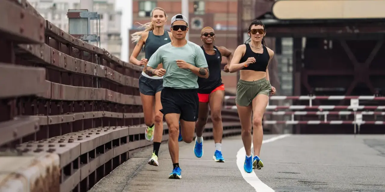 Grupa biegaczy w różnym tempie pokonuje trasę. Intensywny fartlek run na moście miejskim.