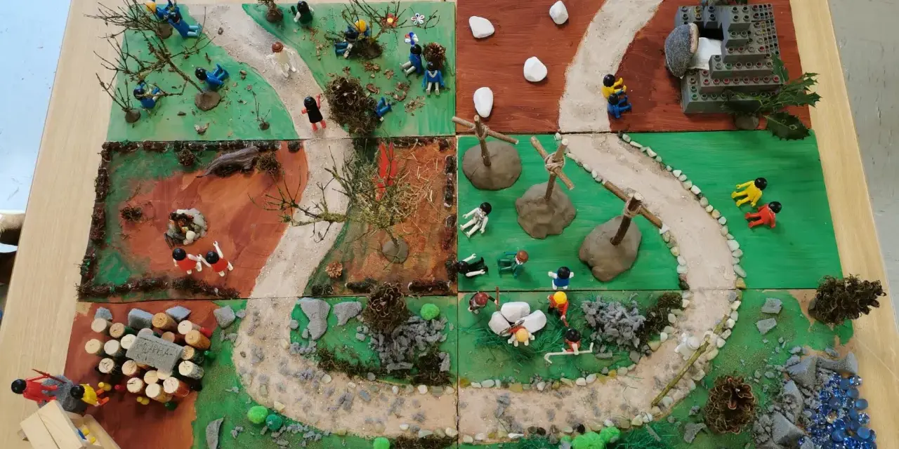 Kinder gestalten einen Kreuzweg mit Spielfiguren und Naturmaterialien. Kleine Szenen zeigen Stationen des Leidenswegs.