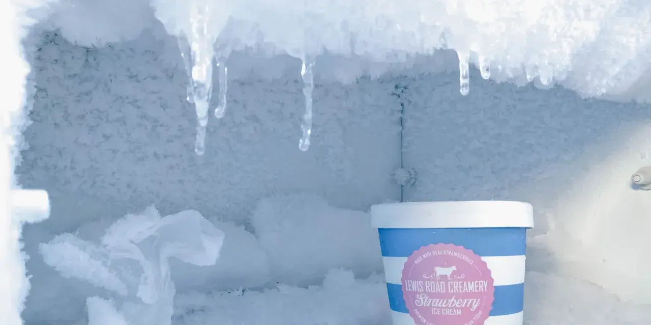 Eisige Eiszapfen hängen über einem Eiscremebecher. Das zeigt, was bedeutet no frost: keine Eisbildung, nur gefrorene Köstlichkeiten.
