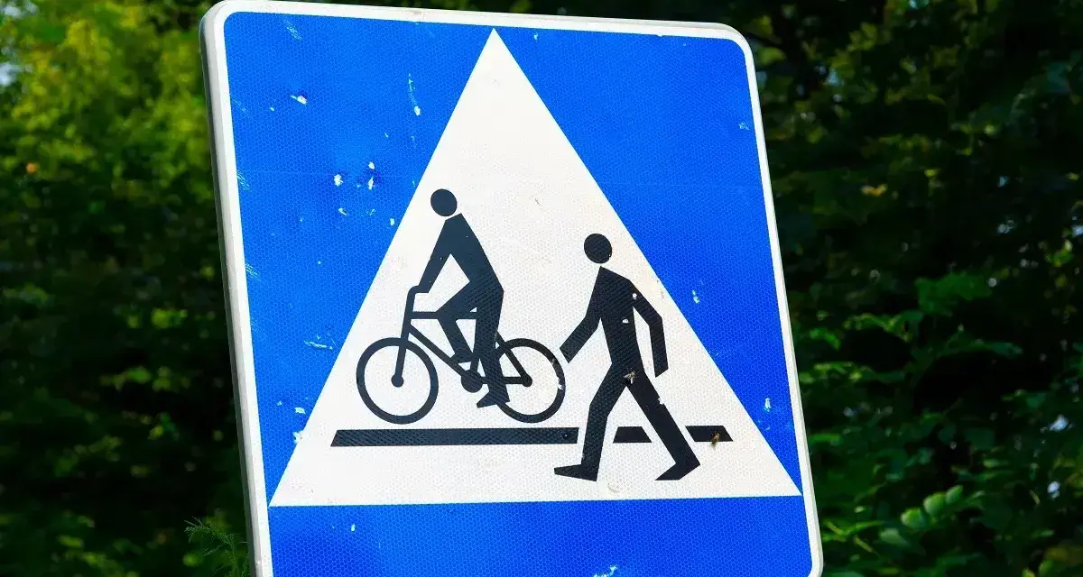 Znak ostrzegawczy: przejazd rowerowy i przejście dla pieszych. Czy rowerzysta ma pierwszeństwo na przejeździe rowerowym? Tak, ten znak informuje o tym.