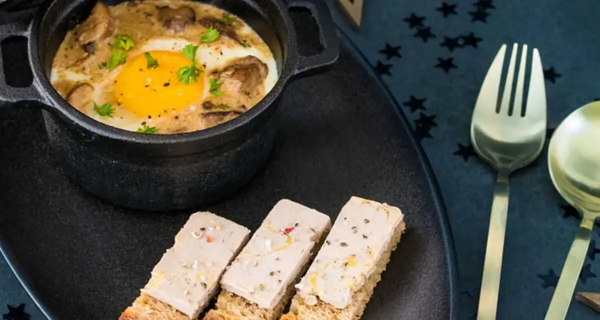 Œuf cocotte aux champignons et foie gras, servi avec des toasts. Un délice pour une recette de fête.