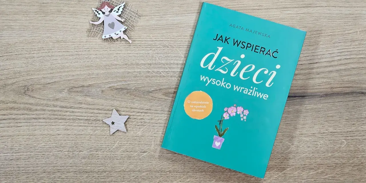 Książka "Jak wspierać dzieci wysoko wrażliwe" obok aniołka i gwiazdki.