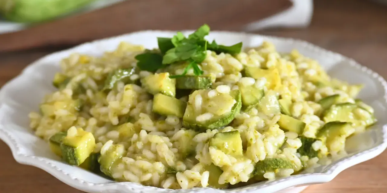 Un cremoso risotto con zucchine, guarnito con prezzemolo fresco, pronto per essere gustato.