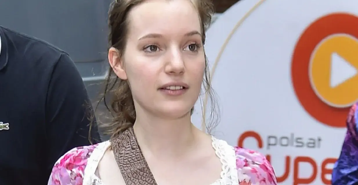 Zuzanna Jurczak, The Voice of Poland, w kwiecistej sukience z koronką, z brązowym paskiem przez ramię.