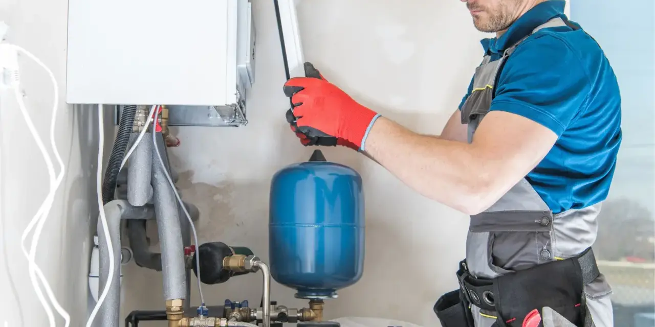 Instalator sprawdza podzespoły kotła gazowego. Zastanawiasz się, ile kosztuje piec gazowy?