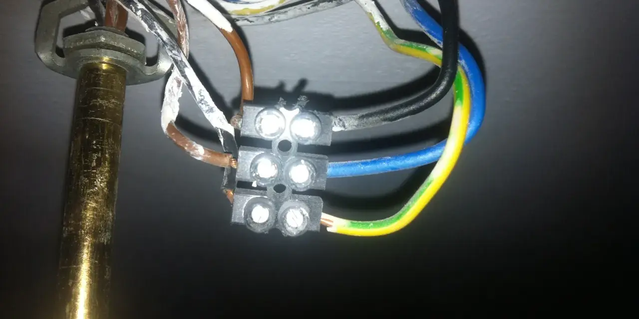 Widok z bliska na połączenie przewodów elektrycznych żyrandola z kostką.