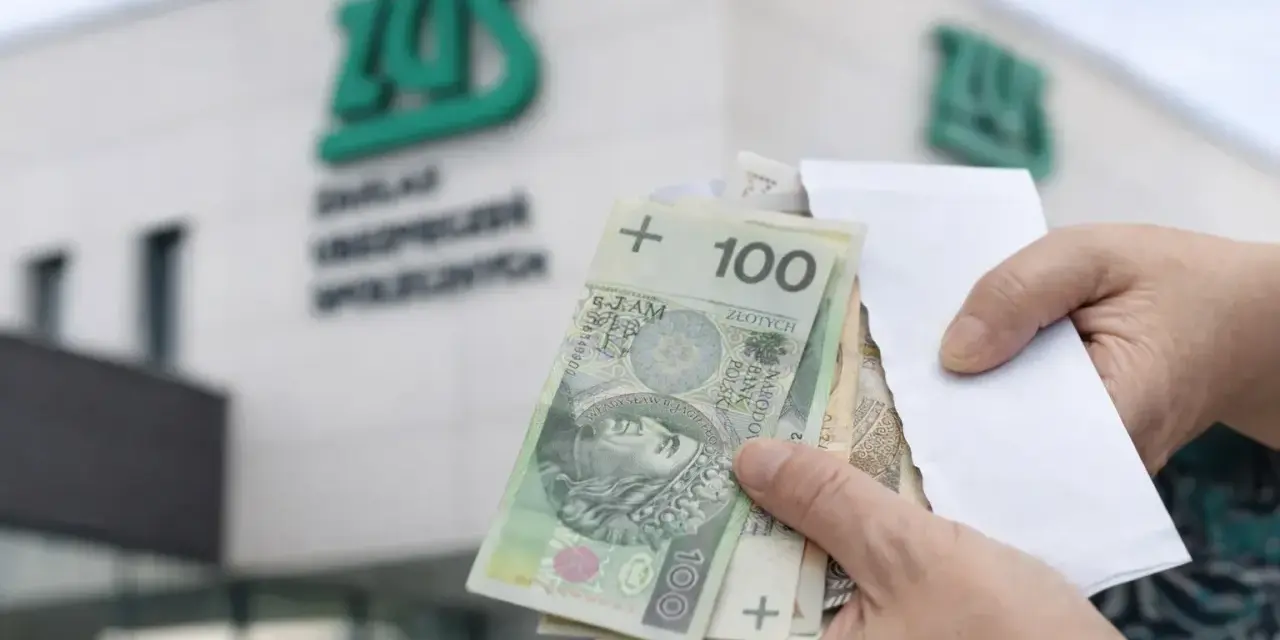 Ręce trzymają polskie banknoty przed budynkiem ZUS. To symboliczny moment, kiedy wypłata 14 emerytury staje się rzeczywistością.