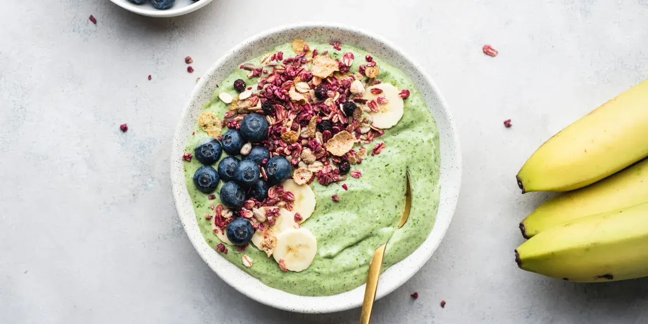 Grön smoothiebowl med blåbär, banan och granola. Ett perfekt proteinrikt mellanmål för en energifylld dag.