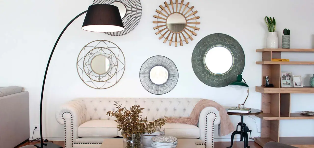 Salón moderno con sofá blanco, lámpara de pie y varios espejos decorativos que siguen principios de feng shui para atraer energía positiva.