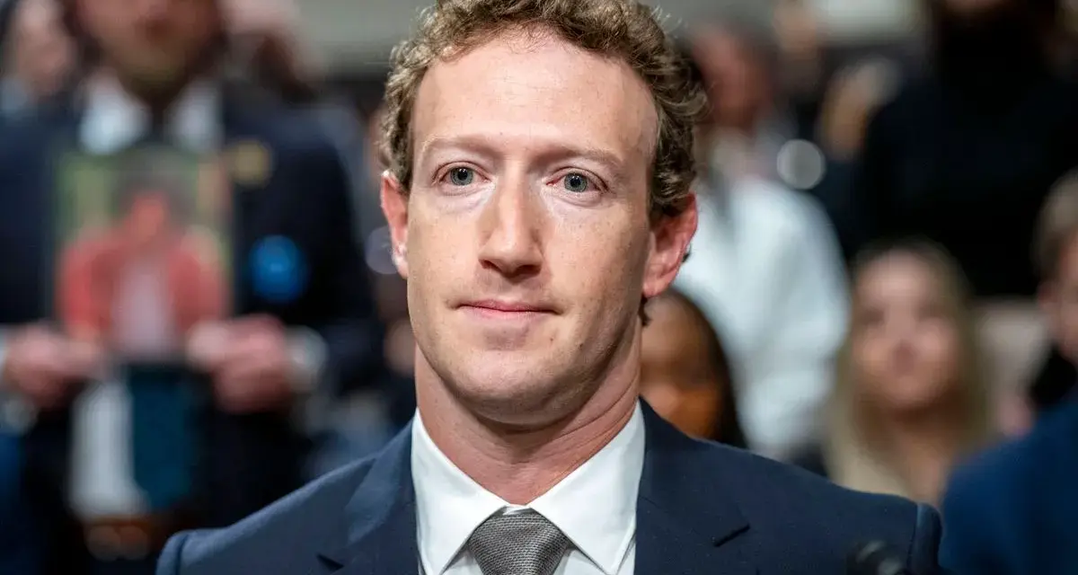 Mark Zuckerberg im Anzug, im Hintergrund unscharfe Menschen und ein Foto.